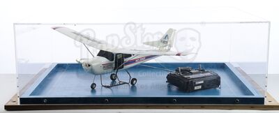 Lot # 64: Episode "Airplane on a Conveyor Belt" (2008, E97): RC Plane and Controller Vitrine