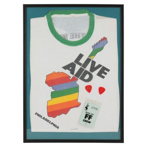 Lot # 130. Framed Live Aid T-Shirt, Eric Clapton-Branded Guitar Picks, and Crew Pass ### LIVE AID (1985)